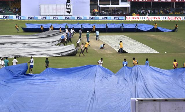 Ground staff covering the pitch and outfields due to rain during 2nd day of 1st Test match between India and New Zealand at Green Park Stadium. (Ajay Aggarwal/HT PHOTO)