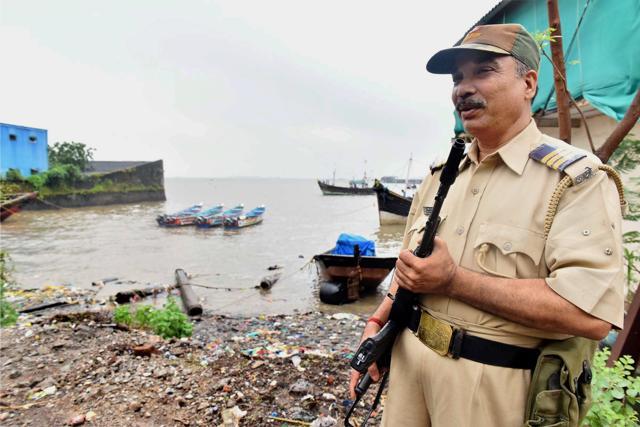 A policeman stands guards near a jetty after the high alert was issued, in Navi Mumbai on Thursday. (PTI) A policeman stands guards near a jetty after the high alert was issued, in Navi Mumbai on Thursday. (PTI)