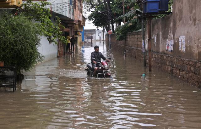 Man rides a motorbike through a waterlogged street in Hyderabad. (AP) Man rides a motorbike through a waterlogged street in Hyderabad. (AP)