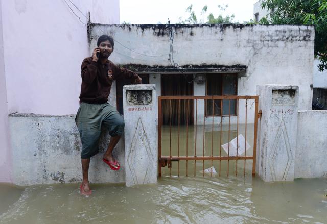 An Indian man speaks on his mobile phone outside his flooded home, following heavy rain in Nijampet a low lying area on the outskirts of Hyderabad on September 21, 2016. (AFP) An Indian man speaks on his mobile phone outside his flooded home, following heavy rain in Nijampet a low lying area on the outskirts of Hyderabad on September 21, 2016. (AFP)