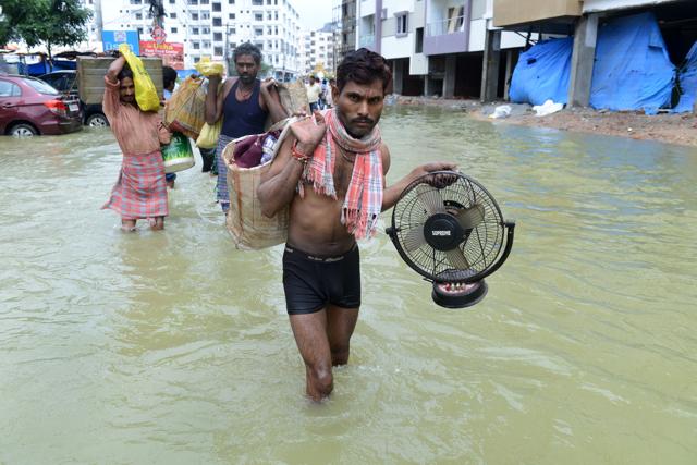 Residents carry their belongings along a flooded street, following heavy rain in Nijampet, a low lying area on the outskirts of Hyderabad on September 21, 2016. (AFP) Residents carry their belongings along a flooded street, following heavy rain in Nijampet, a low lying area on the outskirts of Hyderabad on September 21, 2016. (AFP)