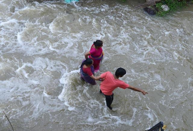 Women receive assistance as they make their way through floodwaters following heavy rain in Nijampet, a low lying area on the outskirts of Hyderabad on September 21, 2016. (AFP) Women receive assistance as they make their way through floodwaters following heavy rain in Nijampet, a low lying area on the outskirts of Hyderabad on September 21, 2016. (AFP)
