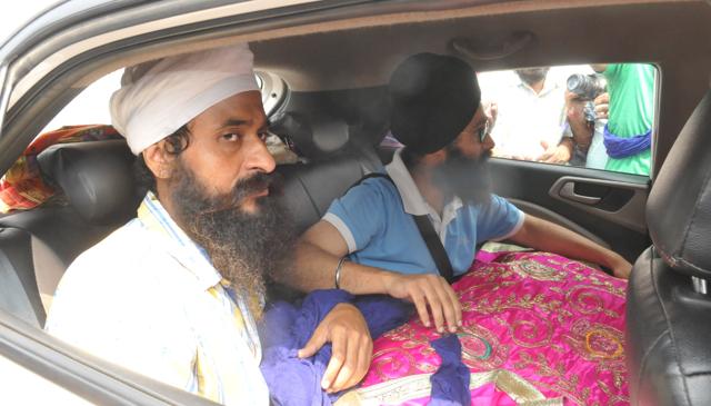 The damaged Guru Granth Sahib being taken away from the spot. (Pardeep Pandit/HT Photo)