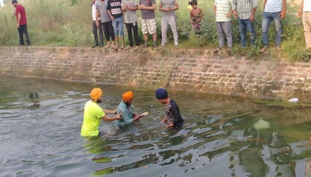 Sikh youth trying to recover more pages of the Guru Granth Sahib. (Pardeep Pandit/HT Photo)