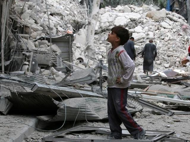 A boy inspects a damaged site after airstrikes on the rebel held Tariq al-Bab neighbourhood of Aleppo, Syria September 23, 2016.(Reuters)