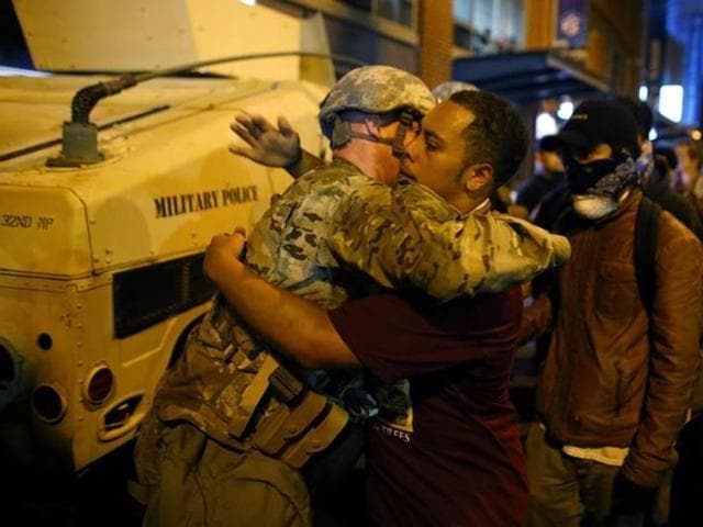 A US National guard soldier accepts a hug from protester as people march through downtown to protest the police shooting of Keith Scott in Charlotte, North Carolina. (Reuters Photo) A US National guard soldier accepts a hug from protester as people march through downtown to protest the police shooting of Keith Scott in Charlotte, North Carolina. (Reuters Photo)