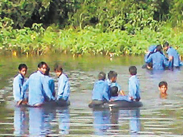 83 children from Machet, Sevachin ka Pura and Madho Singh ka Pura villages of Karauli district put their lives to risk daily to go to school in absence of a bridge over the seasonal river.(HT File Photo)