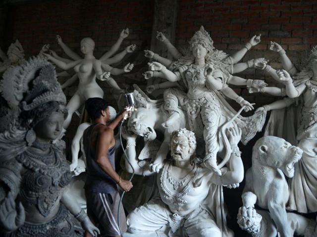 An artisan works on semi-finished clay idols of goddess Durga inside his workshop in Kumartoli, the idol makers' village of Siliguri, on September 22, 2016 The five-day period of worship of Durga, who is attributed as the destroyer of evil, commences on October 7. (DIPTENDU DUTTA/AFP) An artisan works on semi-finished clay idols of goddess Durga inside his workshop in Kumartoli, the idol makers' village of Siliguri, on September 22, 2016 The five-day period of worship of Durga, who is attributed as the destroyer of evil, commences on October 7. (DIPTENDU DUTTA/AFP)