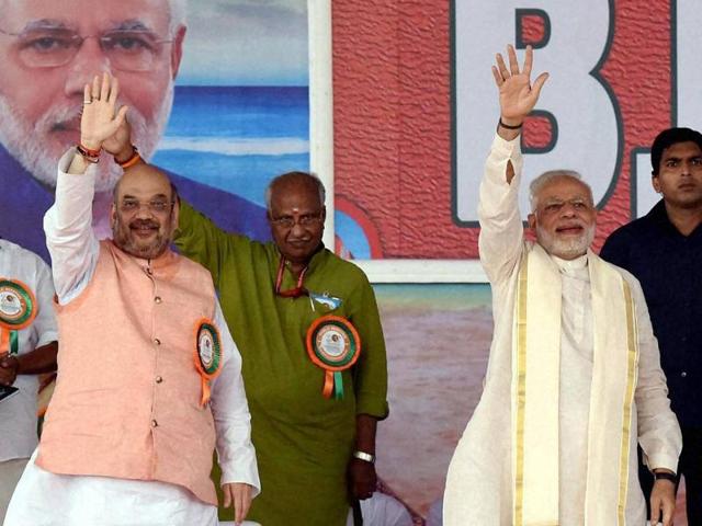 Prime Minister Narendra Modi and BJP president Amit Shah wave to the crowd at public rally during the BJP National council meeting at Kozhikode.(PTI Photo)