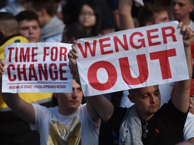 Arsenal fans hold up signs calling for the resignation of Arsenal's French manager Arsene Wenger after the English Premier League football match between Manchester City and Arsenal at the Etihad Stadium in Manchester, north west England, on May 8, 2016. (AFP File Photo)
