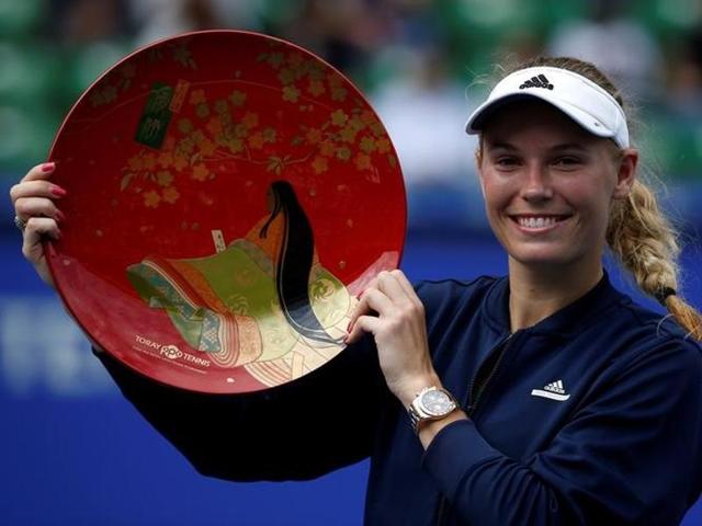 Caroline Wozniacki and Naomi Osaka pose with their trophies after the match.(Reuters)