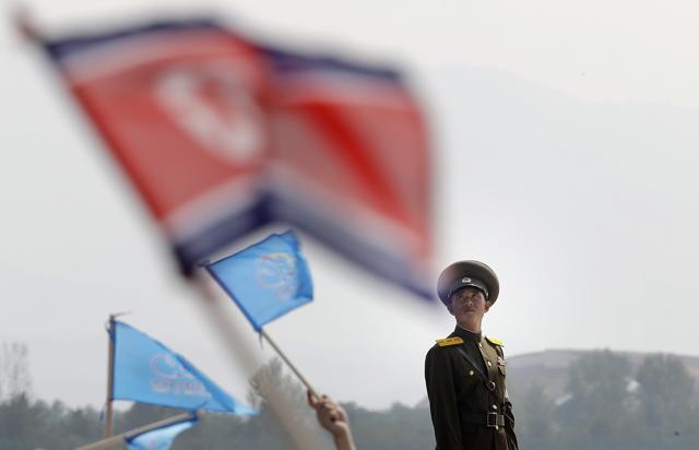 A North Korean military soldier stands guard as North Koreans wave flags and cheer during an aerial display, in Wonsan, North Korea. (AP Photo) A North Korean military soldier stands guard as North Koreans wave flags and cheer during an aerial display, in Wonsan, North Korea. (AP Photo)