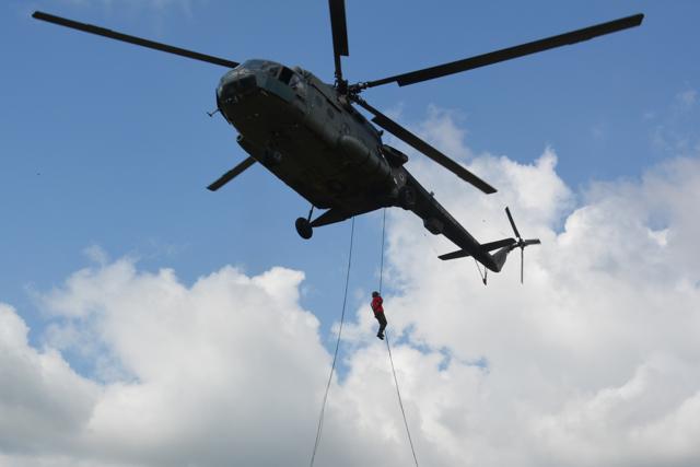 A soldier climbing down a rope attached to a helicopter during anti-terrorist mock drills. (Army)