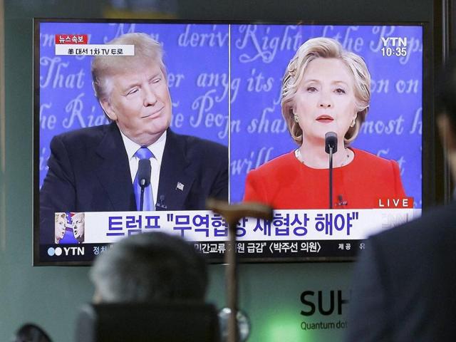 People in Seoul watch a TV screen showing the live broadcast of the US presidential debate between Democratic presidential nominee Hillary Clinton and Republican presidential nominee Donald Trump.(AP)