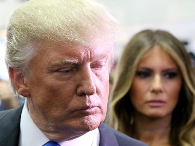 Republican presidential nominee Donald Trump speaks to the media in the spin room as wife, Melania Trump (right) looks on during the presidential debate at Hofstra University. (AFP Photo)