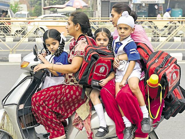 Parents picking up their children from school during the strike of school van operators in Amritsar on Monday.(Gurpreet Singh/HT) Parents picking up their children from school during the strike of school van operators in Amritsar on Monday.(Gurpreet Singh/HT)