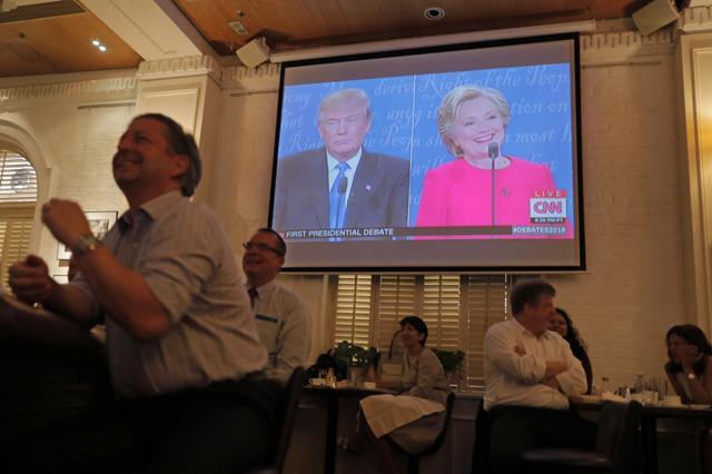 People watch live broadcasting of the US presidential debate between Democratic presidential nominee Hillary Clinton and Republican presidential nominee Donald Trump, at Foreign Correspondents' Club in Hong Kong. (AP) People watch live broadcasting of the US presidential debate between Democratic presidential nominee Hillary Clinton and Republican presidential nominee Donald Trump, at Foreign Correspondents' Club in Hong Kong. (AP)