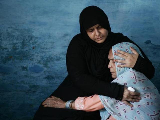 Asgari Begum (right), mother of Mohammad Ikhlaq, being consoled by a relative,a day after the 55-year-old man and his younger son Danish were attacked by an angry mob over allegations of sacrificing a cow and storing its meat for consumption.(Burhaan Kinu/HT Photo)