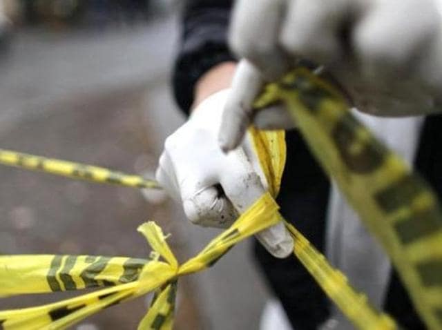 A forensic technician ties a used police line together to seal off a crime scene.(Reuters File Photo) A forensic technician ties a used police line together to seal off a crime scene.(Reuters File Photo)