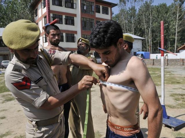 A policeman measures the chest of a Kashmiri youth during an special police officer (SPO) recruitment rally in Ganderbal, 20 km from Srinagar(HT)