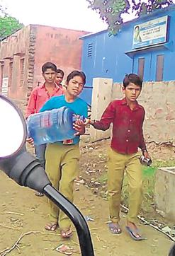 Students carry 20 litre water jars from a water purifying plant to their school in Bharatpur. (HT Photo) Students carry 20 litre water jars from a water purifying plant to their school in Bharatpur. (HT Photo)