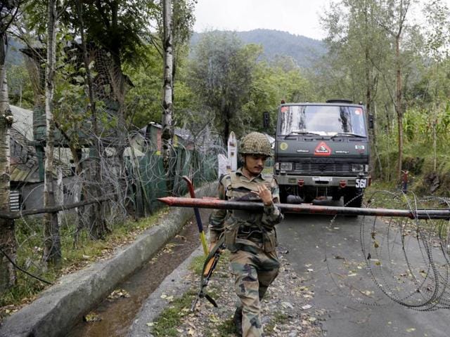 A soldier lifts an iron barricade to allow a vehicle to drive out of a military base at Braripora, near the de facto border dividing Kashmir between India and Pakistan.(AP File Photo) A soldier lifts an iron barricade to allow a vehicle to drive out of a military base at Braripora, near the de facto border dividing Kashmir between India and Pakistan.(AP File Photo)