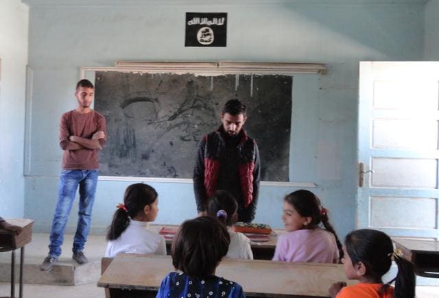 Syrian children sit at a classroom adorned with an Islamic State group insignia on the first day of classes in the Syrian town of Manbij.(AFP Photo) Syrian children sit at a classroom adorned with an Islamic State group insignia on the first day of classes in the Syrian town of Manbij.(AFP Photo)