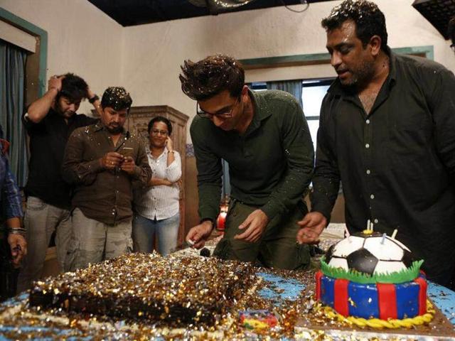 Director Anurag Basu looks on as Ranbir cuts his birthday cakes.