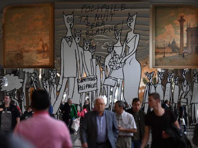 People walk near an artwork by French artist Alain Sechas, set up in the Gare de Lyon. (AFP) 
