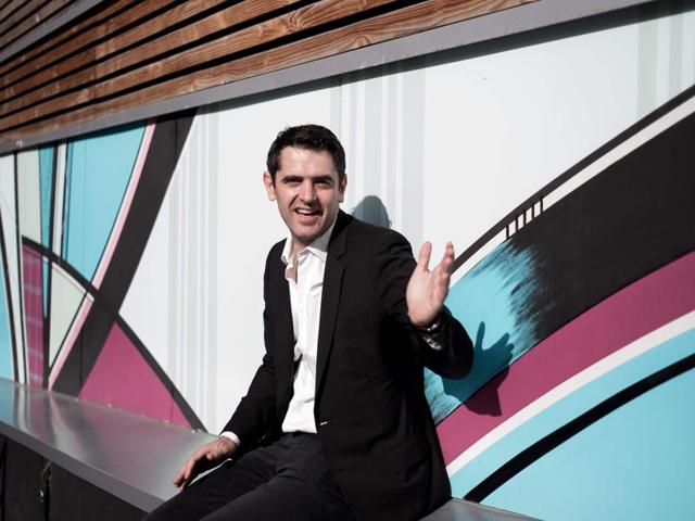French urban art collector Nicolas Laugero Lasserre poses in front of a wall decorated with street art at the 'Ecole 42' computer programming school. (AFP) 