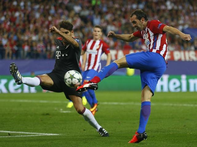 Atletico's Diego Godin, right, shoots the ball as Bayern's Javi Martinez tries to stop him.(AP Photo)