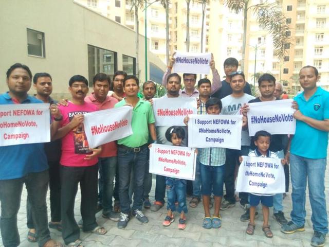 Homebuyers who are still waiting to get their homes in Greater Noida West pose with the NoHouseNoVote slogan which they have tweeted.(\)