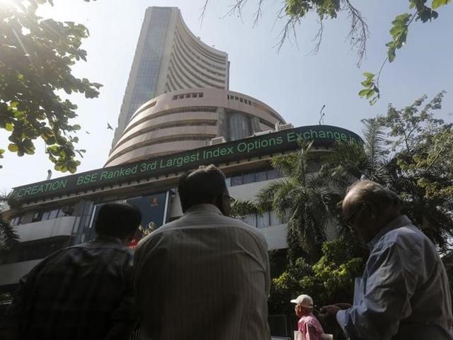 People watch a large screen displaying Sensex on the facade of the Bombay Stock Exchange.(Reuters)