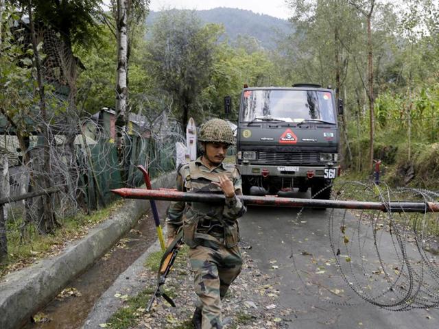 An Indian Army soldier lifts an iron barricade to allow a vehicle to drive out of a military base at Braripora, near the de facto border with Pakistan.(AP Photo) An Indian Army soldier lifts an iron barricade to allow a vehicle to drive out of a military base at Braripora, near the de facto border with Pakistan.(AP Photo)
