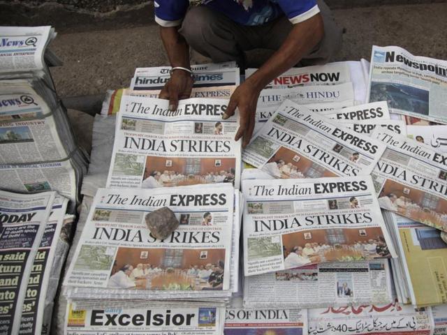 A newspaper vendor arranges morning newspapers carrying headlines of India's military strikes, in Jammu.(AP)