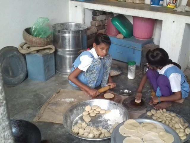 The photograph shows the two girls preparing the mid-day meal in school uniform at the Imlanpurva Government Primary School on the outskirts of Chhatarpur that went viral.