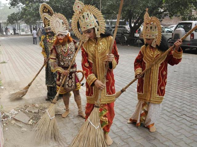 Ramlila artistes from Navyug group of Sector 7 take part in a cleanliness drive at the plaza in Sector 17, Chandigarh, on Saturday. (Karun Sharma/HT)