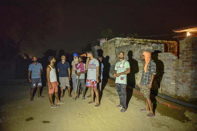 Village men keep guard at Roranwala late Friday late evening.