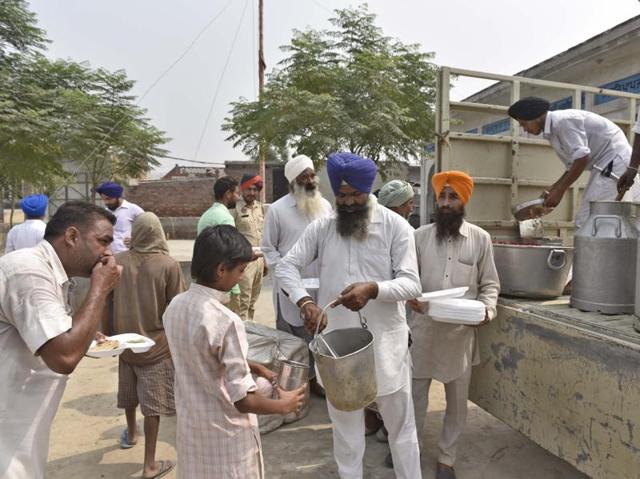 Langar (community food service) by SGPC workers for villagers of Rattan Khurd near the border fence in Amritsar sector on Saturday, October 1. (Gurpreet Singh/HT Photo) 