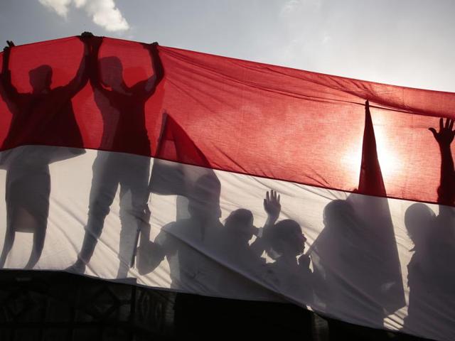 Men are silhouetted against a large representation of the Yemeni flag as they attend a ceremony to mark the anniversary of North Yemen's revolution in Sanaa, Yemen. Men are silhouetted against a large representation of the Yemeni flag as they attend a ceremony to mark the anniversary of North Yemen's revolution in Sanaa, Yemen.