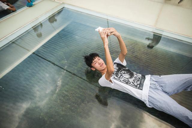 A visitor lies down to take a photograph on the glass-bottomed bridge. (AFP File Photo) A visitor lies down to take a photograph on the glass-bottomed bridge. (AFP File Photo)