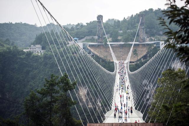 The world's highest and longest glass-bottomed bridge is seen above a valley in Zhangjiajie in China's Hunan Province on August 21, 2016. / AFP PHOTO / FRED DUFOUR (AFP) The world's highest and longest glass-bottomed bridge is seen above a valley in Zhangjiajie in China's Hunan Province on August 21, 2016. / AFP PHOTO / FRED DUFOUR (AFP)