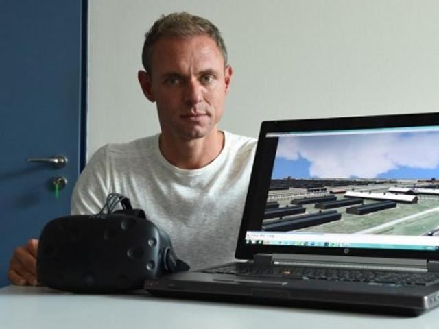 This photo taken on September 26, 2016 in Munich, southern Germany, shows Ralf Breker of the Bavarian criminal police posing with virtual reality glasses and a computer which shows a picture from the 3D model of the former Nazi concentration camp Auschwitz. (AFP) This photo taken on September 26, 2016 in Munich, southern Germany, shows Ralf Breker of the Bavarian criminal police posing with virtual reality glasses and a computer which shows a picture from the 3D model of the former Nazi concentration camp Auschwitz. (AFP)