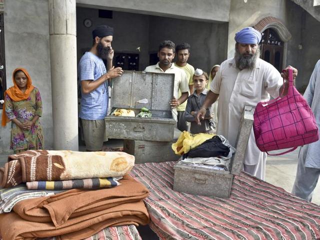 Satnam Singh (in blue turban), and other family members pack their belongings in Mullakot village, some 20 metres away from the border fence in Amritsar sector, near Attari boarder area, Punjab . (Gurpreet Singh/HT Photo) Satnam Singh (in blue turban), and other family members pack their belongings in Mullakot village, some 20 metres away from the border fence in Amritsar sector, near Attari boarder area, Punjab . (Gurpreet Singh/HT Photo)