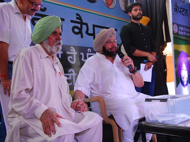 Punjab Congress president Captain Amarinder Singh with Captain Kikkar Singh (retd), his former army colleague from the 1962 war with China, during a programme at Budhlada in Mansa district.(HT Photo)