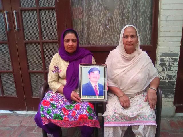 Rani Devi (left) holding the picture of her husband, landmine victim Parshotam Lal, at Ferozepur’s Gola Ka Maur village. (HT Photo) Rani Devi (left) holding the picture of her husband, landmine victim Parshotam Lal, at Ferozepur’s Gola Ka Maur village. (HT Photo)