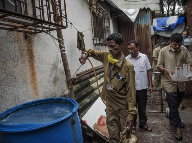 The BMC staff during an inspection. Health officials say clearing old water helps reduce breeding spots. (Satish Bate/HT PHOTO)