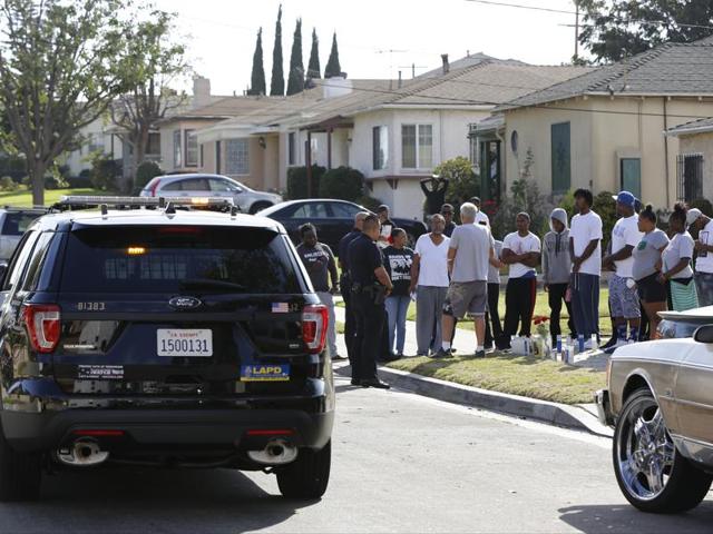 Los Angeles Police officers stop their patrol vehicle to speak to neighbours and members of the community gathered around a makeshift memorial outside a residence on Sunday. Officers shot and killed Carnell Snell Jr. in south Los Angeles on Saturday at the end of a car chase. (AP) Los Angeles Police officers stop their patrol vehicle to speak to neighbours and members of the community gathered around a makeshift memorial outside a residence on Sunday. Officers shot and killed Carnell Snell Jr. in south Los Angeles on Saturday at the end of a car chase. (AP)