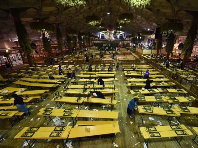 Employees clean up inside an empty festival tent after the end of the 183th Oktoberfest. (AFP) 