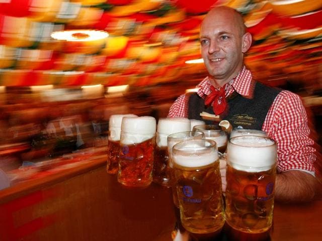 A waiter serves mugs of beer during the opening of the Oktoberfest in Berlin. (REUTERS) 